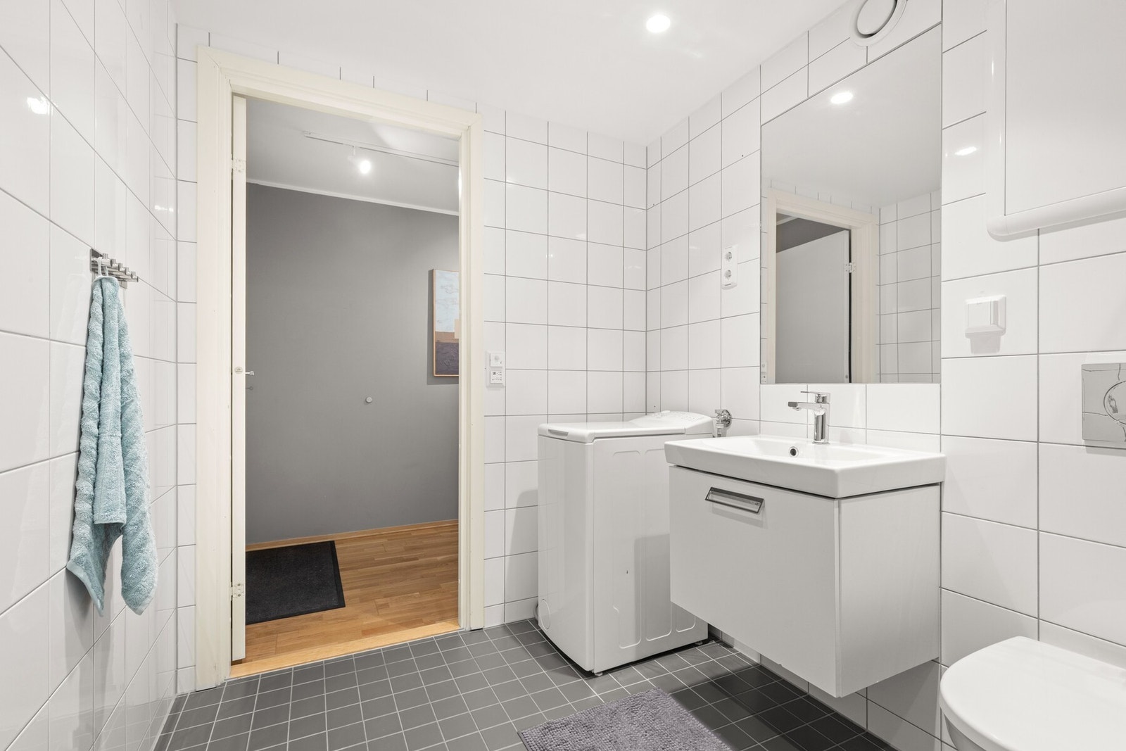 Moderne baderom fra byggeår (2012) bestående av flislagte vegger og flislagt gulv, nedforet malt himling med innfelte downlights og varmekabler i gulv. Galleribilde