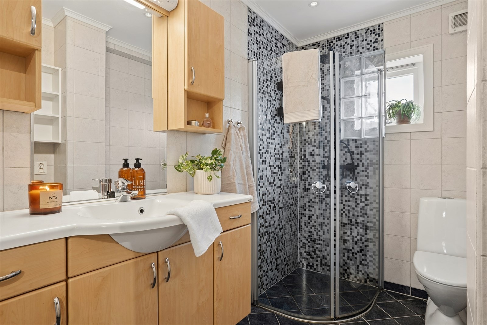 Badet i 1.etg er flislagt med varmekabler og downlights i himling. Galleribilde