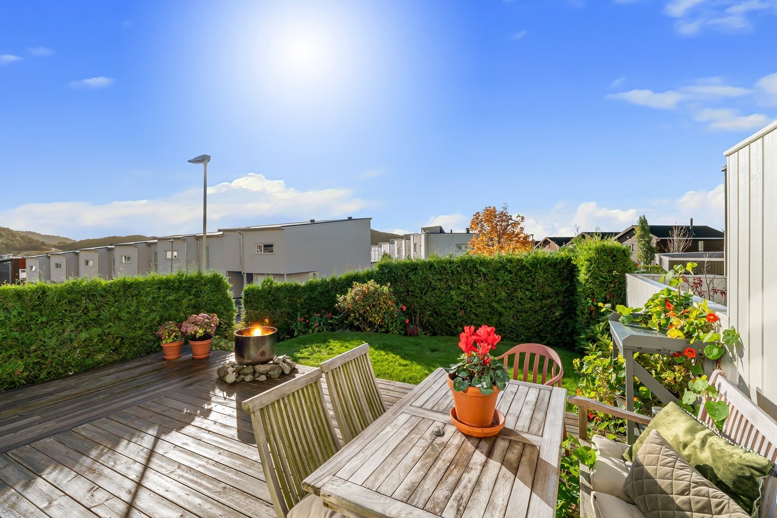 Pent opparbeidet endetomt med belegningsstein ved inngangsparti, solrik terrasse, gressplen med gjerde og hekk i nabogrense. Galleribilde