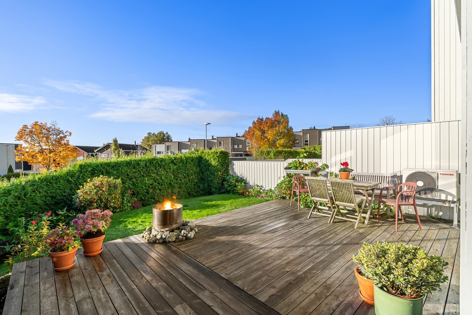 Pent opparbeidet endetomt med belegningsstein ved inngangsparti, solrik terrasse, gressplen med gjerde og hekk i nabogrense. Galleribilde