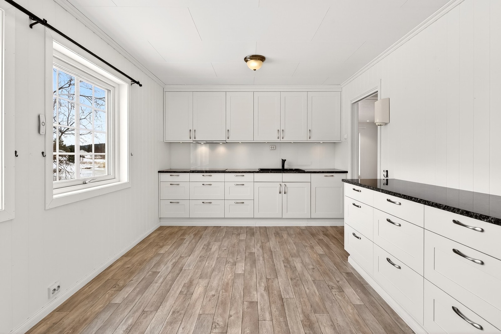 Lyst og funksjonelt kjøkken med gode arbeidsflater og rikelig med oppbevaring. Galleribilde