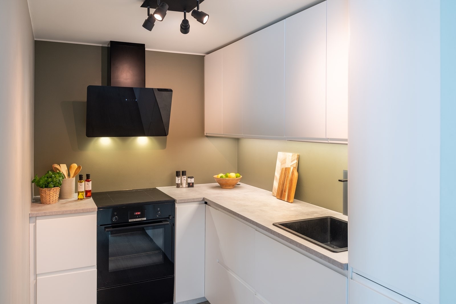 Kjøkkenet fremstår stilrent med slette fronter og under/-overskap. Av integrerte hvitevarer er det oppvaskmaskin og kjøl-/fryseskap. Galleribilde