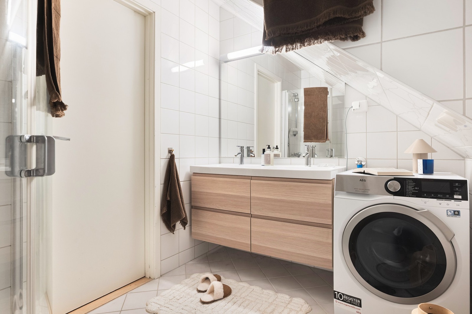 Badet har dusj med glassvegger, toalett, baderomsinnredning og opplegg for vaskemaskin. Galleribilde