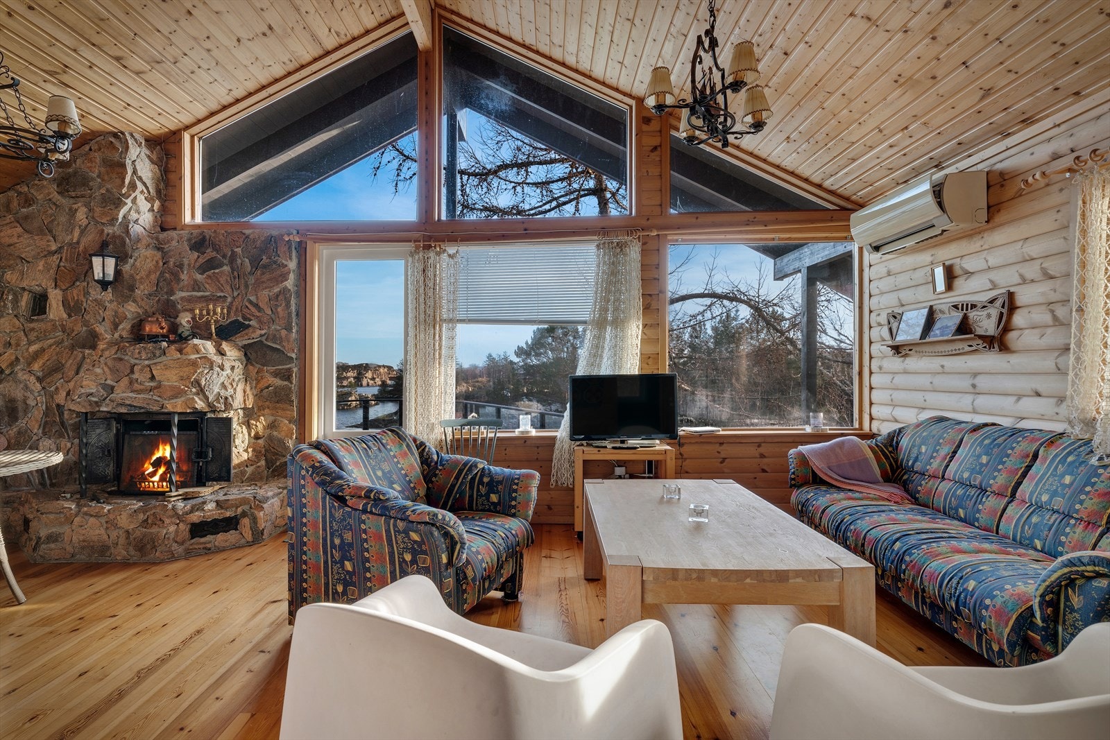 Den steinbelagte peisen med innsats skaper et naturlig samlingspunkt i stuen. Galleribilde