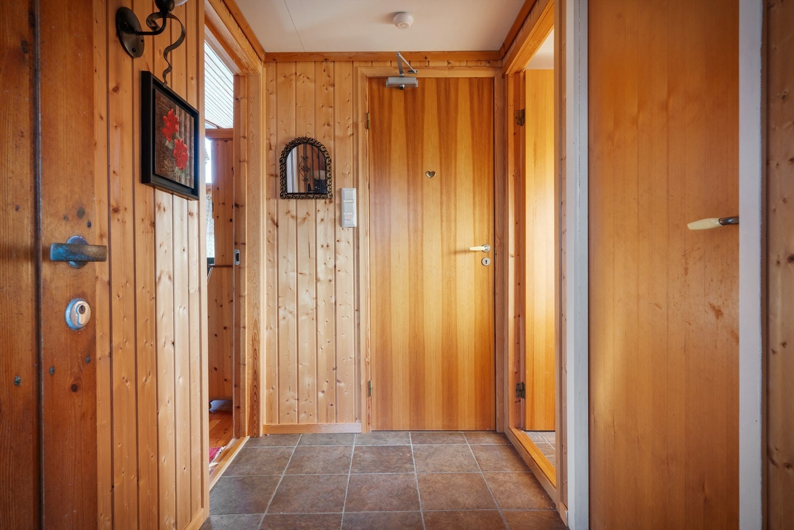 Entréen ønsker velkommen inn i en hytte med gjennomgående trepanel og en lun atmosfære. Galleribilde