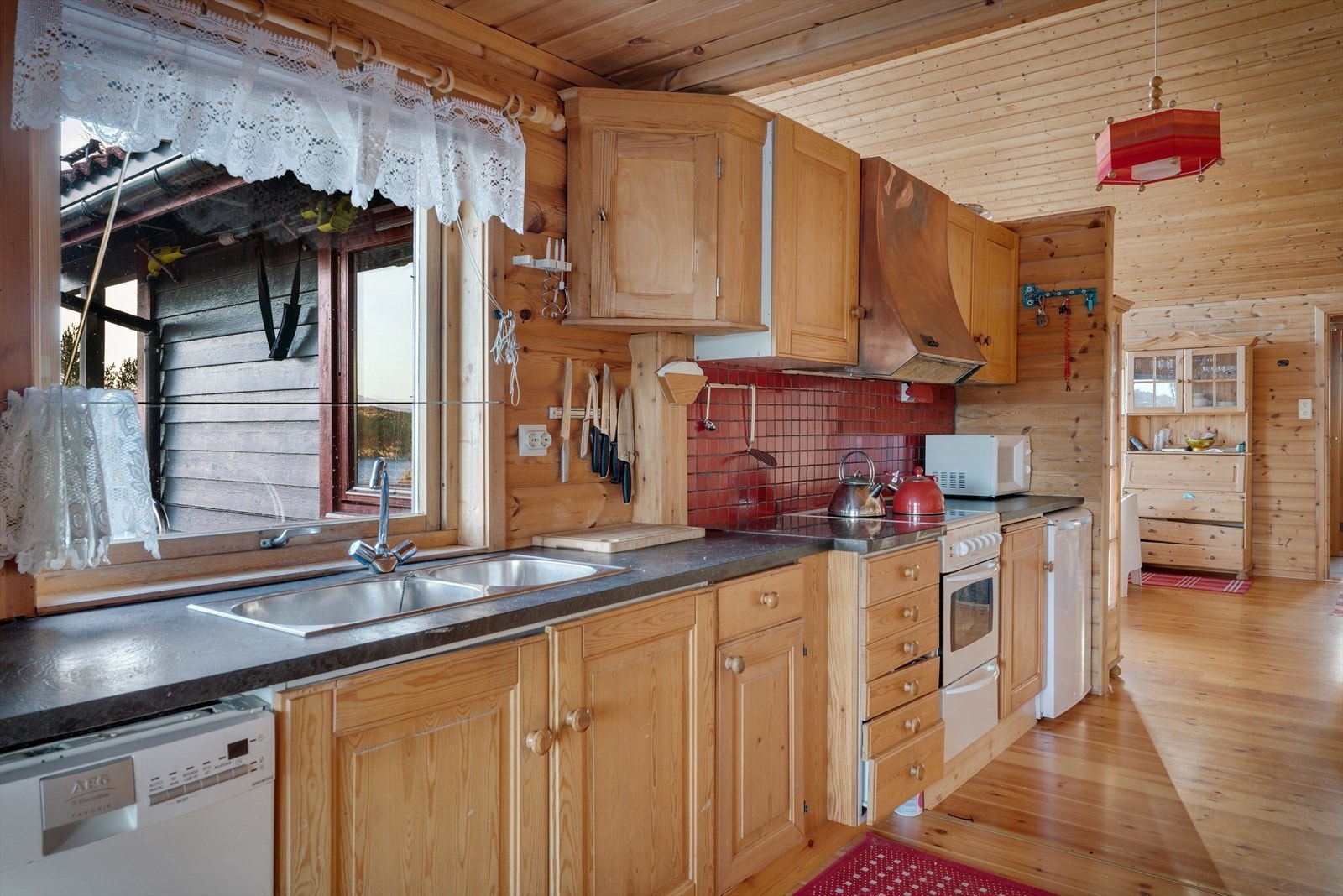 Benkeplaten i laminat suppleres av en polert steinplate ved komfyren. Galleribilde