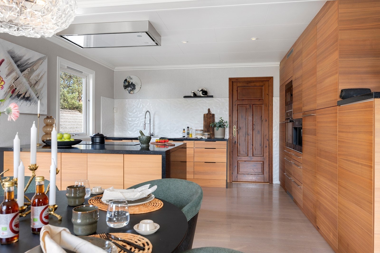 Husets kjøkken er et moderne og klassisk rom med slette fronter og benkeplate i slitesterk kompositt med underlimt vask. Galleribilde