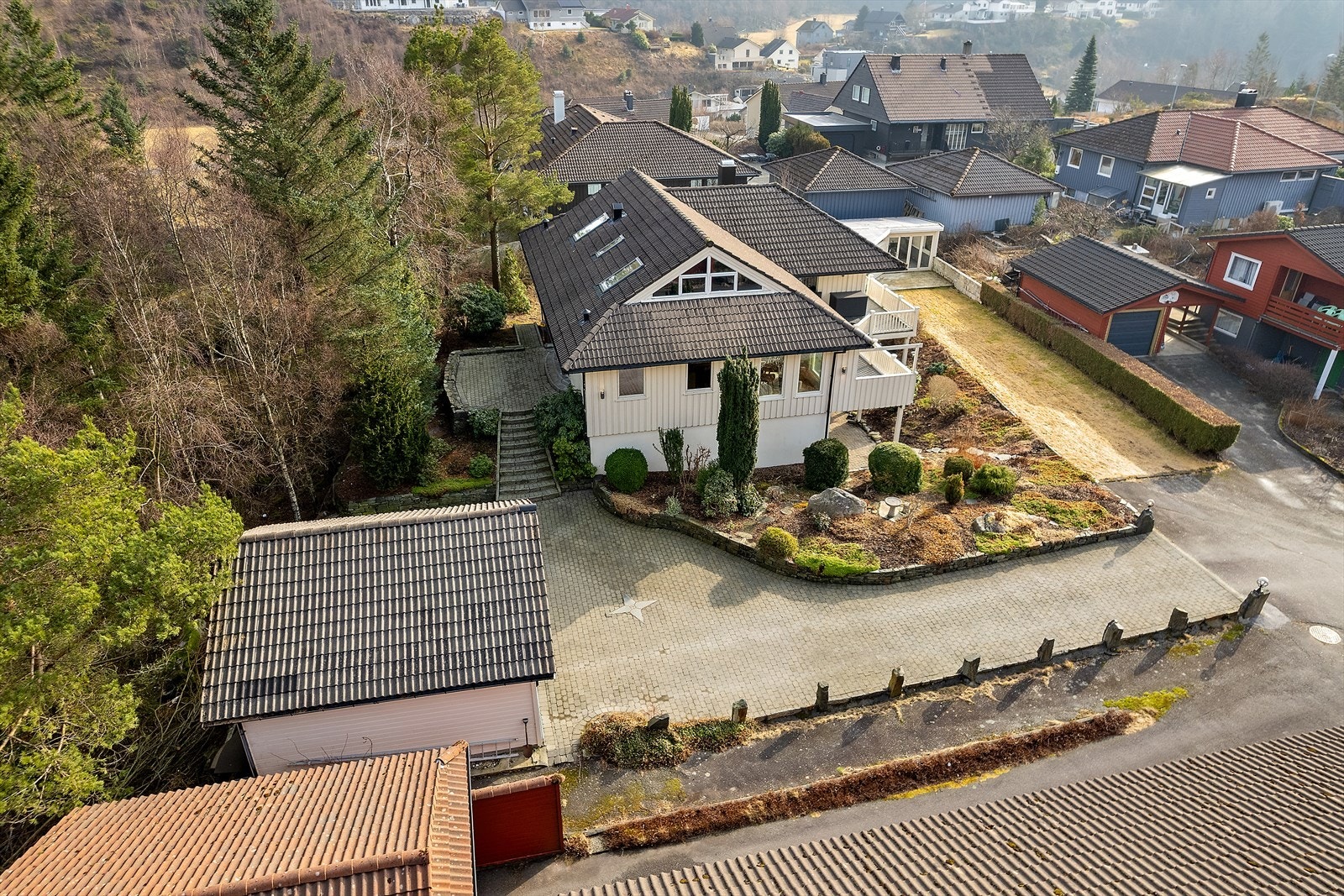 Hagen er pent beplantet med busker, planter og trær som skaper en idyllisk ramme rundt boligen. Galleribilde