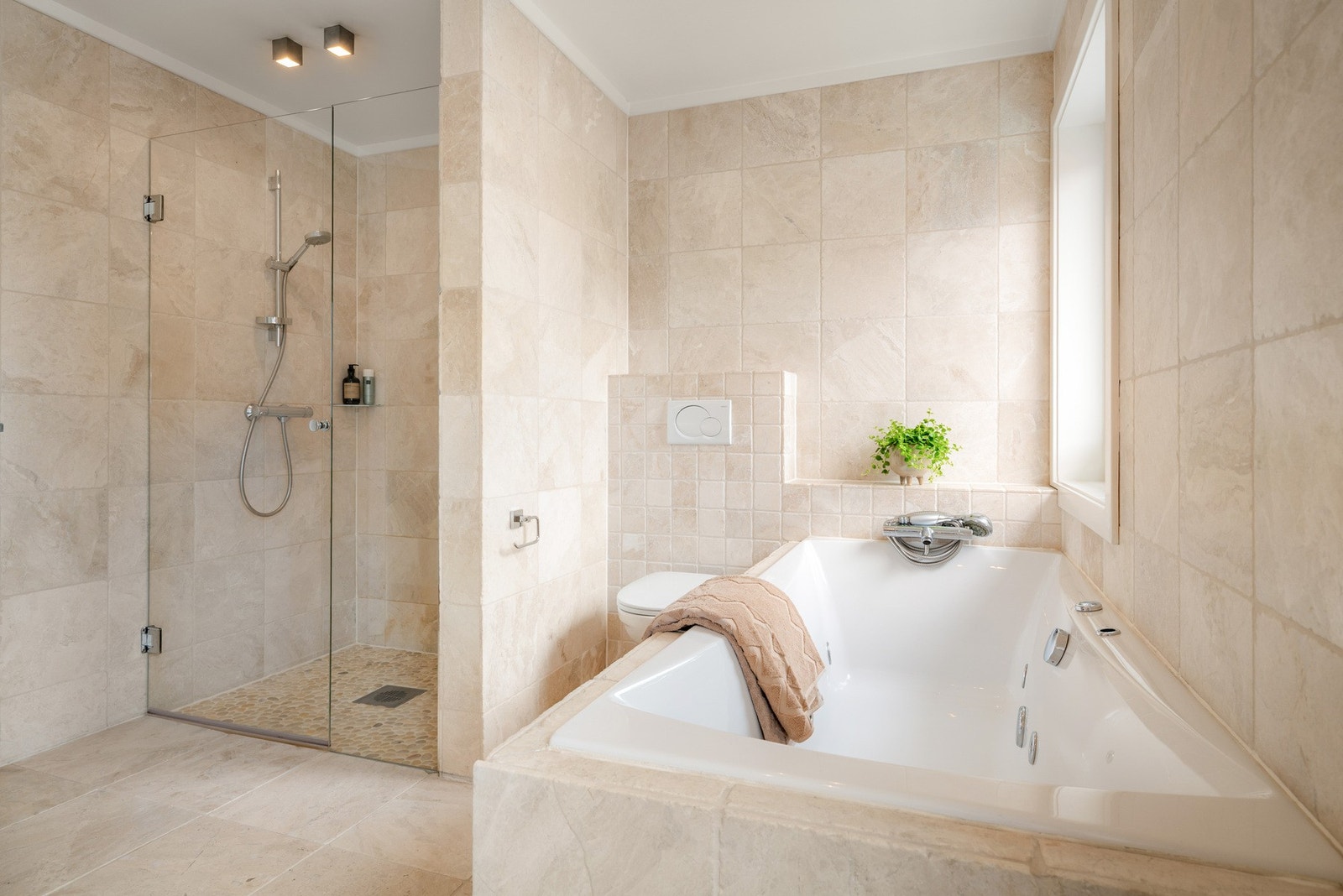 Vegghengt wc, innebygd boblebad og dusjnisje med svingdør og glassfelt. Galleribilde