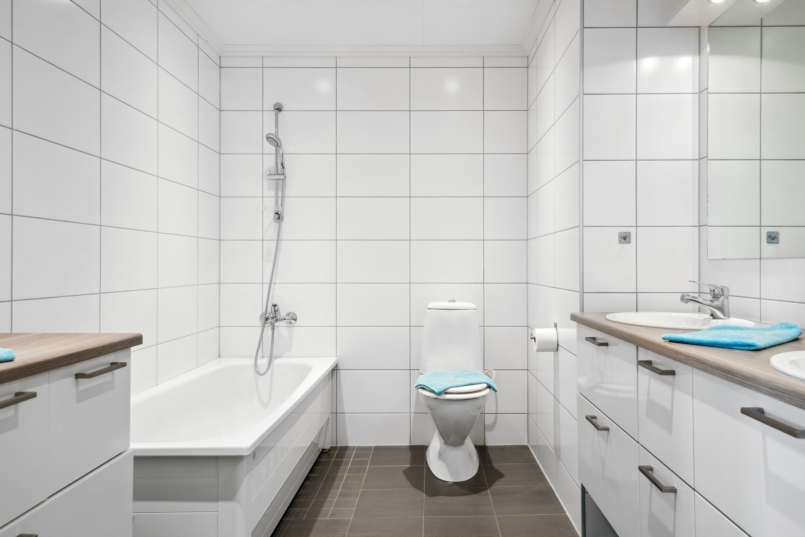 Moderne bad med dusj, badekar og dobbeltservant. Elegant design og praktisk innredning for en komfortabel hverdag. Galleribilde