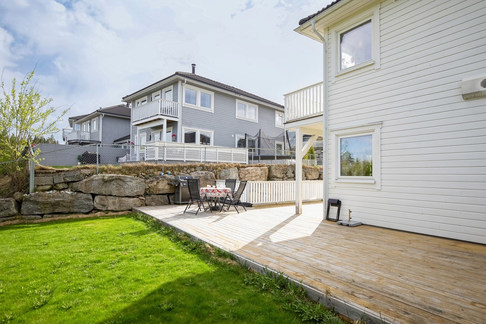 Fin uteplass med gressbelagt plen på flat tomt. Galleribilde