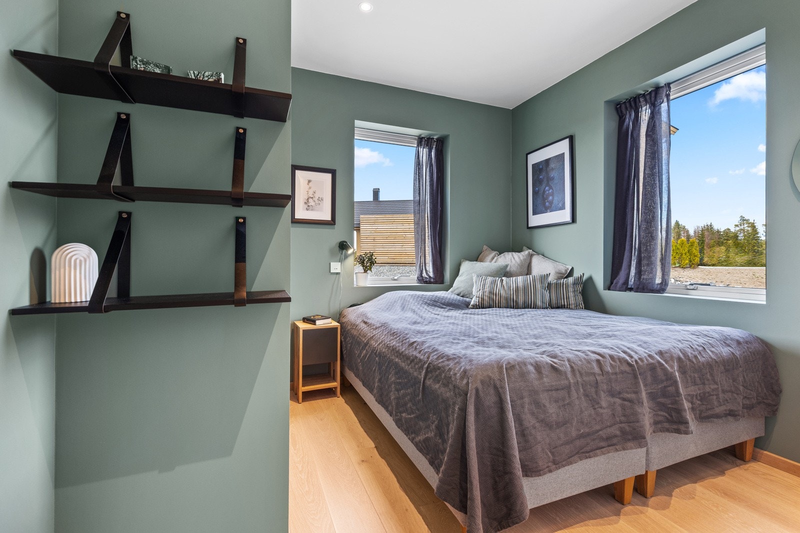 Soverom 2 fremstår som et koselig soverom med malte slette veggflater, lyspigmentert enstavs parkett på gulv og store vindusflater som slipper inn rikelig med lys. Galleribilde