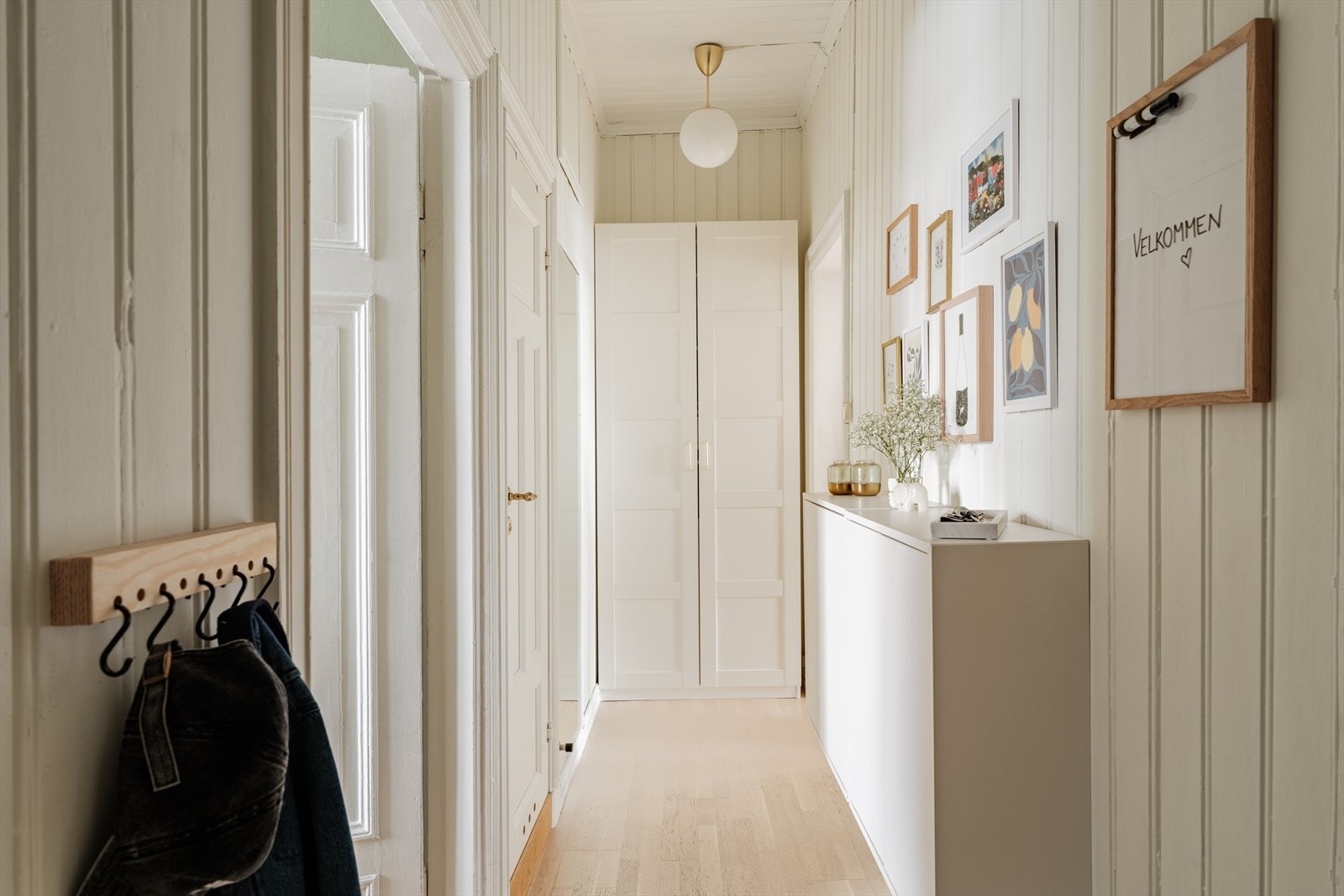 Gangen er romslig med god plass til å henge fra seg ytterjakker på knagger, skoskap, vegghengt hylle og garderobeskap i enden av gangen. Galleribilde