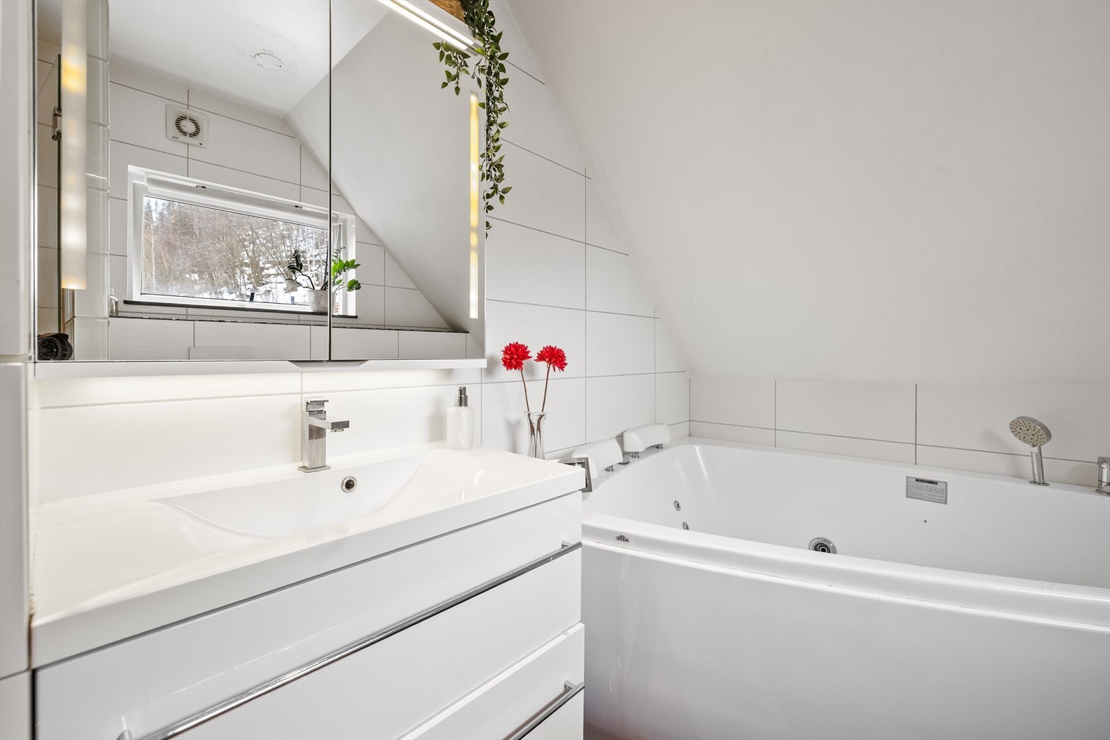 Det er servant med skuffinnredning og speilskap for oppbevaring av toalett gjenstander. Galleribilde