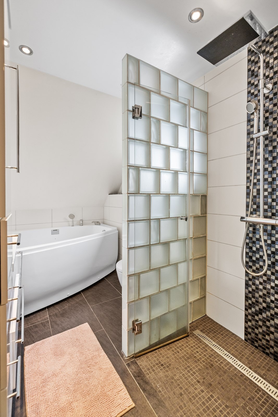 Badet i denne etasjen er innredet med romslig dusjnisje med glassbyggerstein og glassdør. Galleribilde