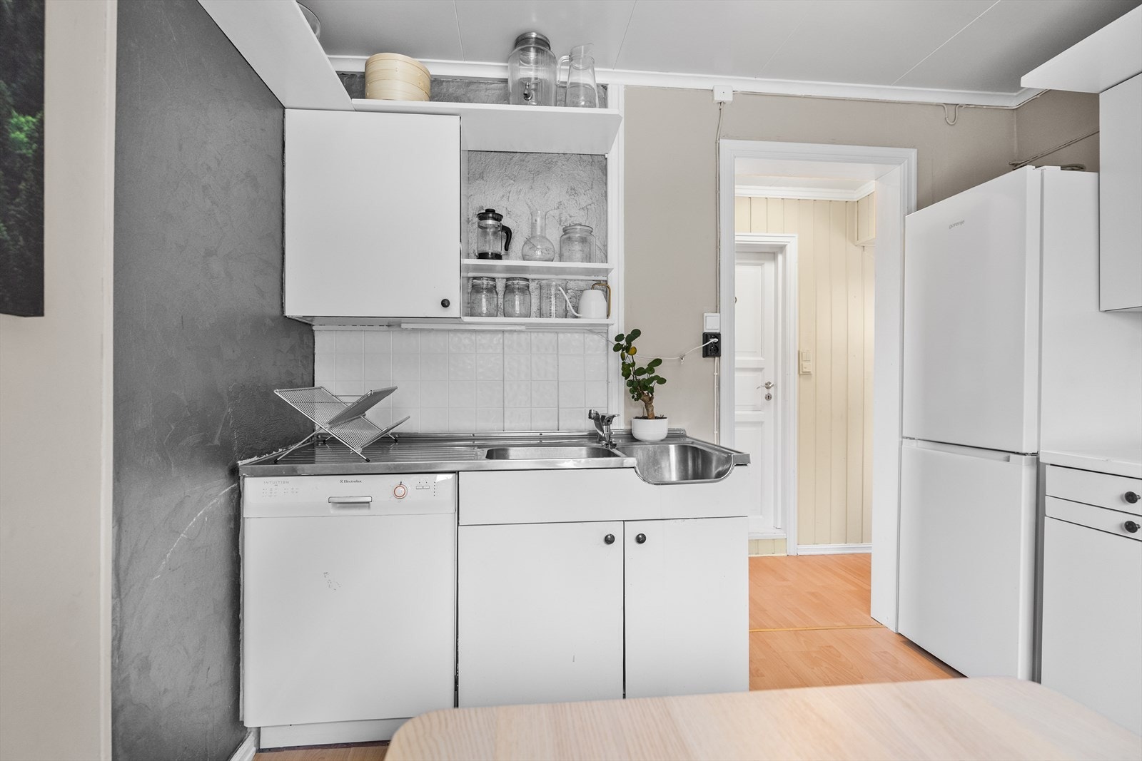 Det er montert hvite kjøkkenplater mellom benk og overskap. Galleribilde