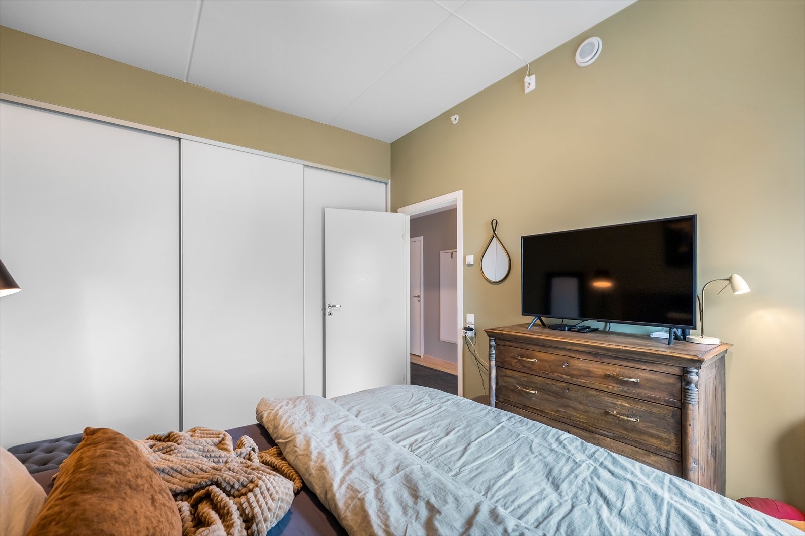 En store garderobe skjult bak tre skyvedører gir godt med lagringsplass Galleribilde