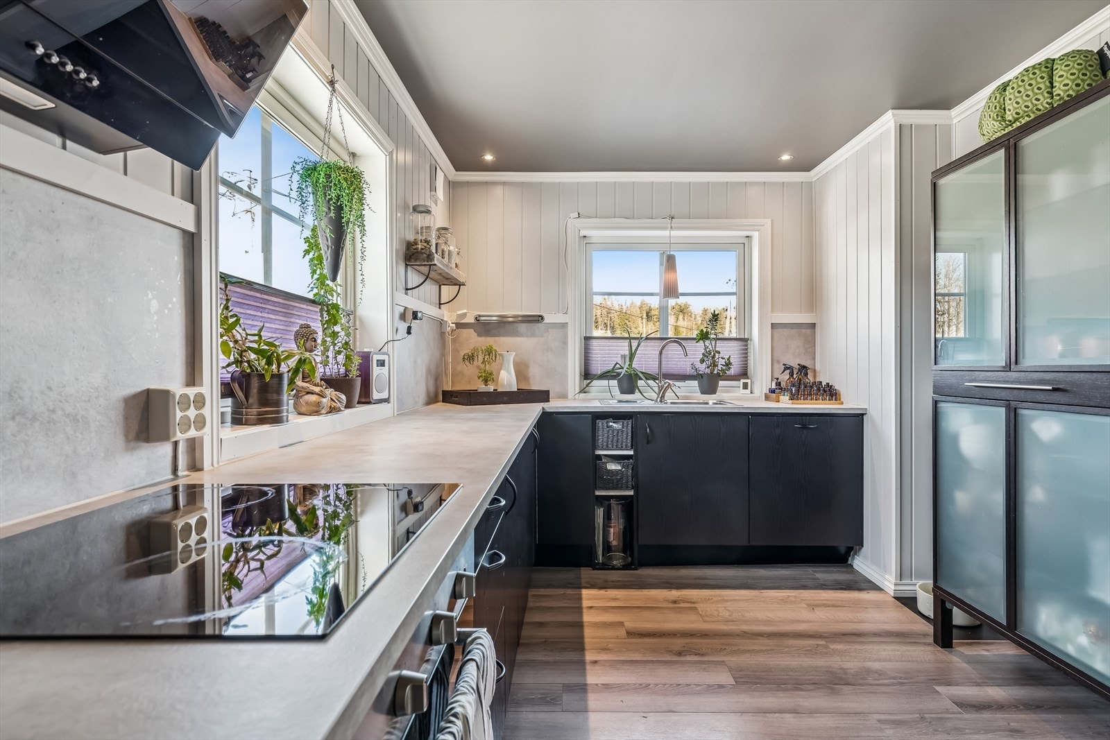 Benkeplaten i laminat har en nedfelt kum i rustfritt stål og kjøkkenplater på veggen. Galleribilde