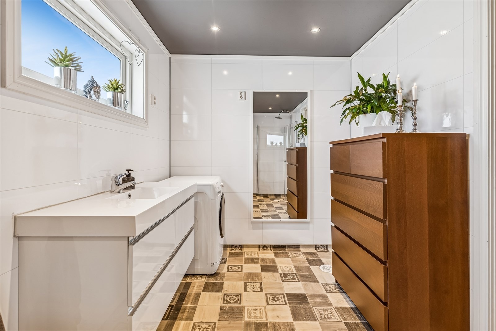 Her er det baderomsinnredning med heldekkende servant, skuffer og opplegg for vaskemaskin. Galleribilde