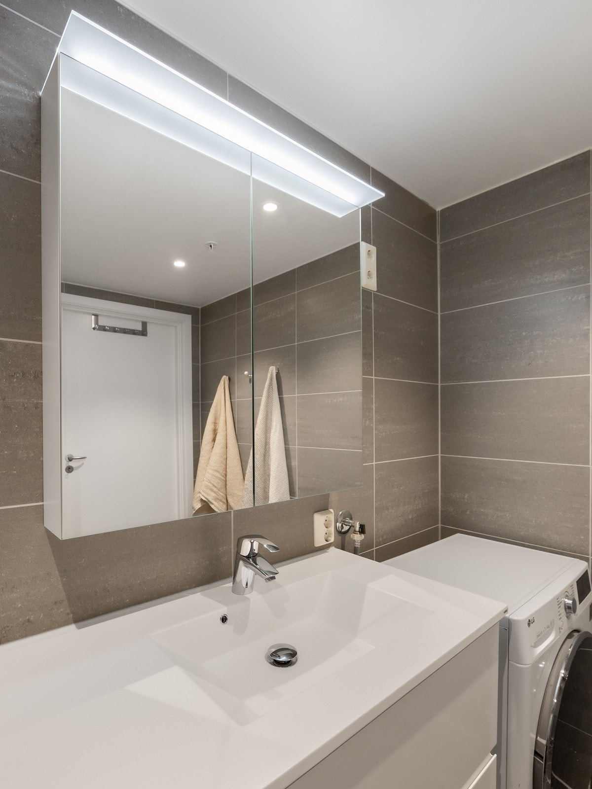 Baderommet har en moderne stil og er i tillegg praktisk utformed med servantinnredning og speilskap med god oppbevaring. Galleribilde