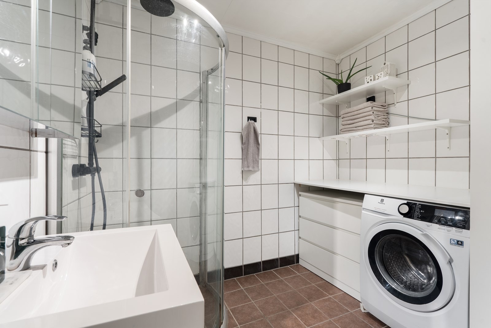 Baderom med opplegg til vaskemaskin, dusjkabinett, servant og WC Galleribilde