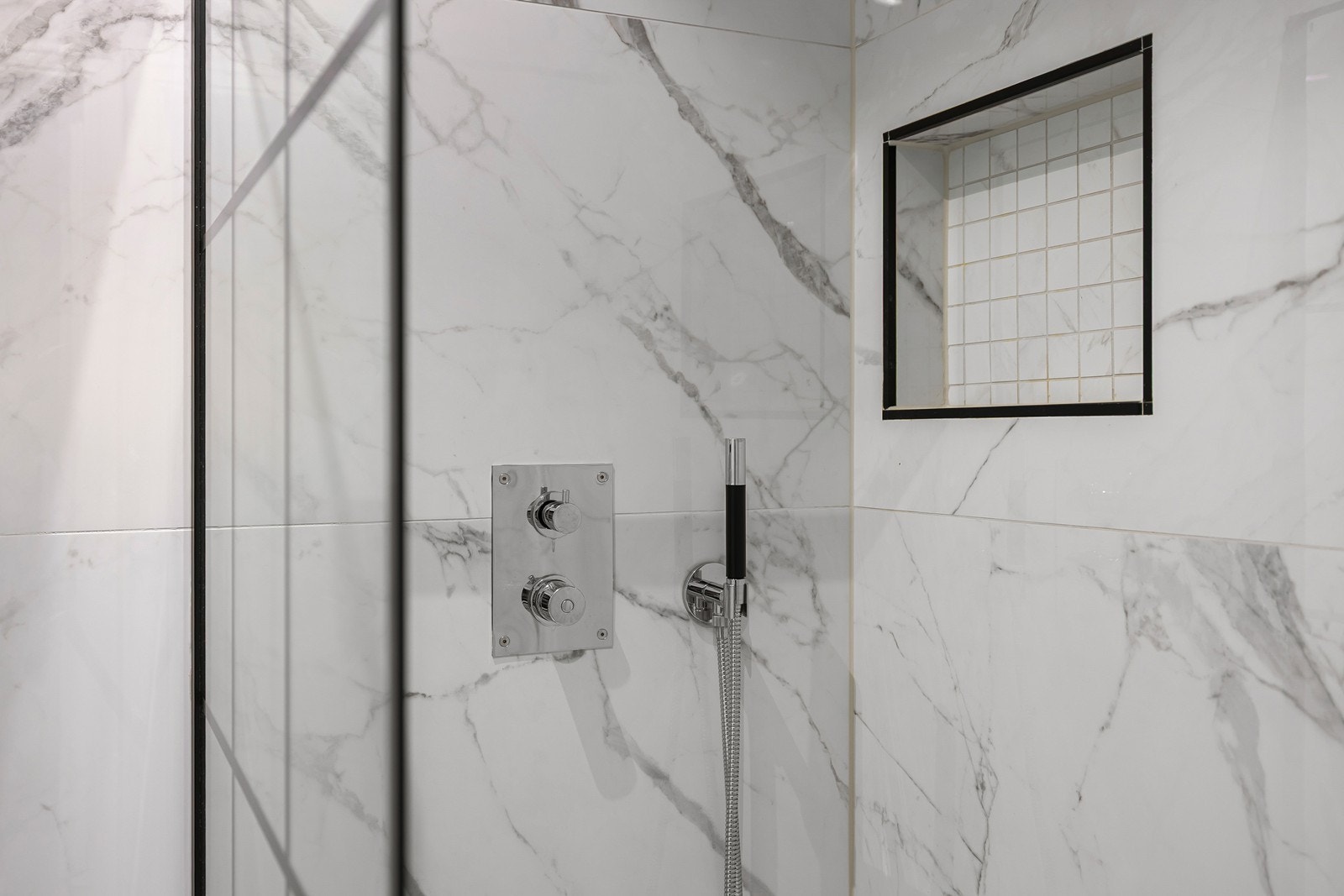 I dusjsonen er det bygget inn en praktisk og stilren nisje for oppbevaring av såpe og sjampo, noe som gir et ryddig uttrykk og fjerner behovet for eksterne hyller. Galleribilde