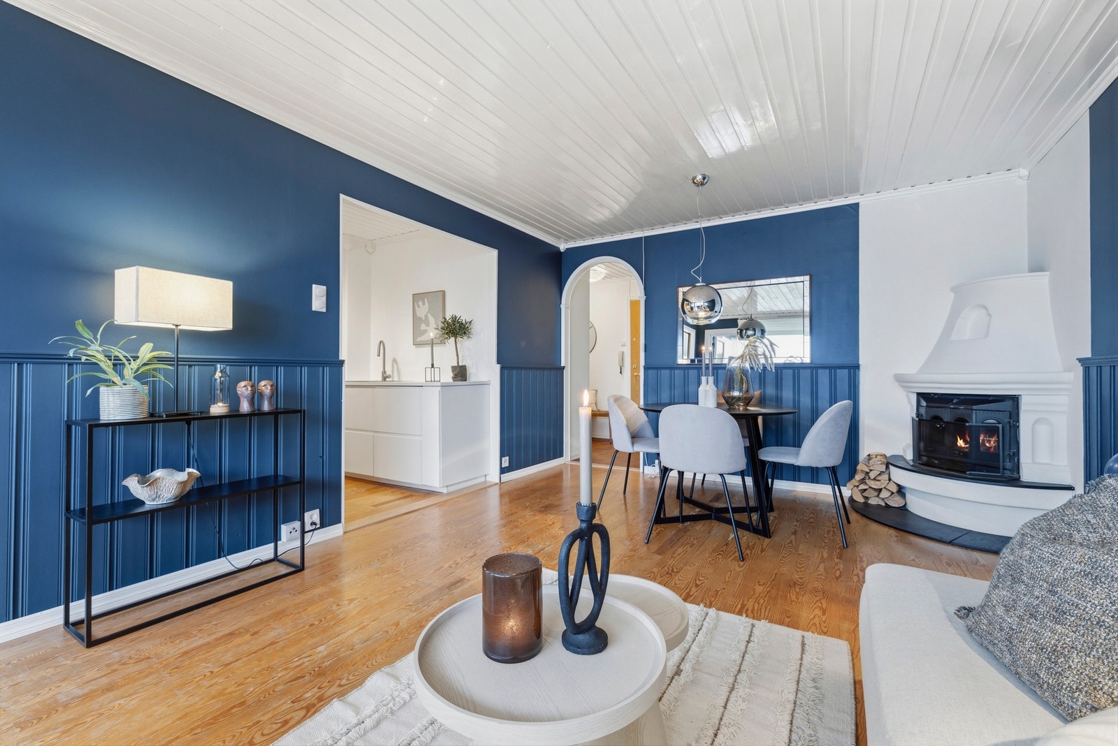 Leiligheten har en koselig hjørnepeis med innsats i stuen, som bidrar til lun stemning Galleribilde