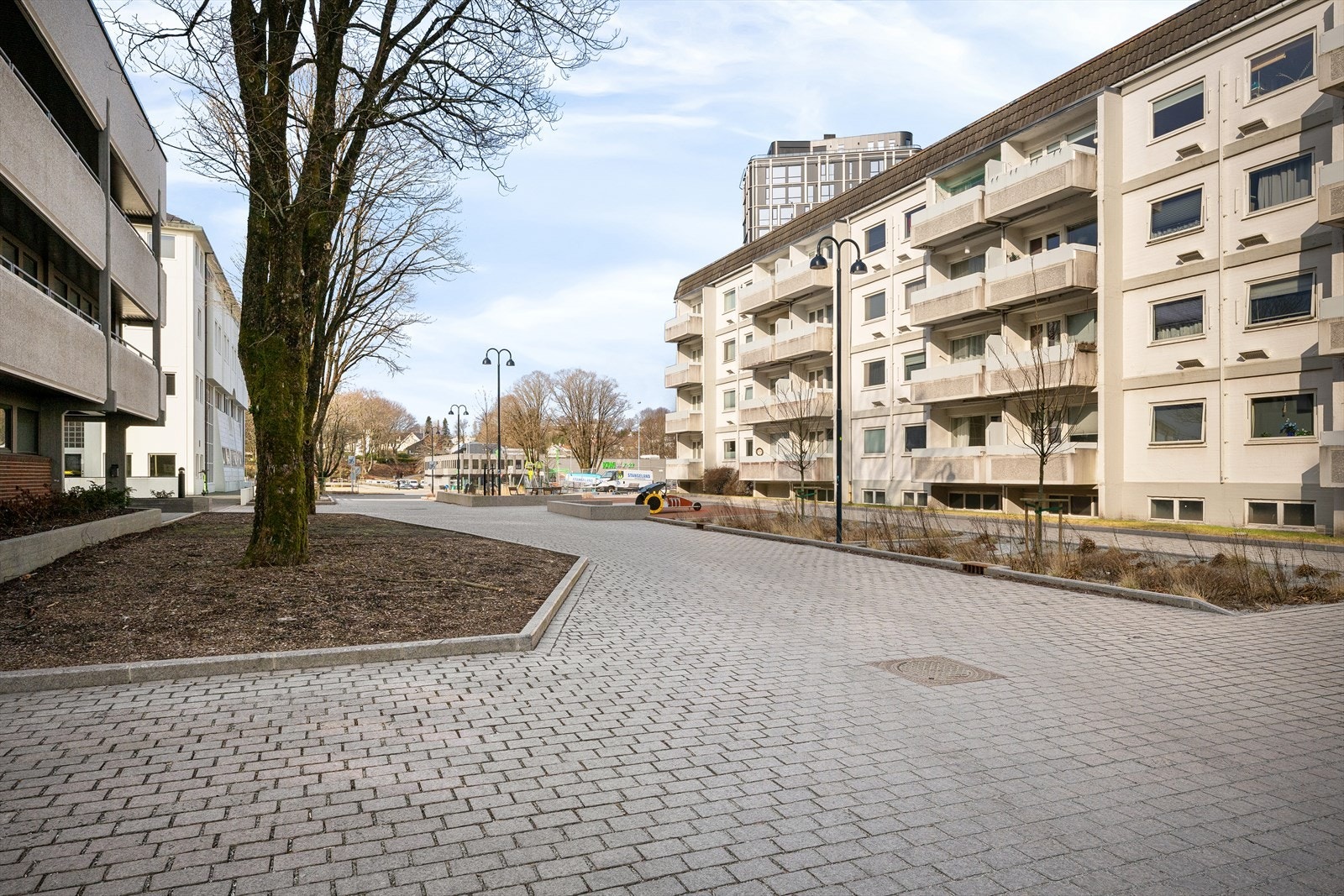 Snart ferdigstilt miljøgate med flott stein, sittegrupper og bed med beplantning. Et koselig og godt bomiljø trukket tilbake i ytterkant av sentrum med parken som nabo. Galleribilde