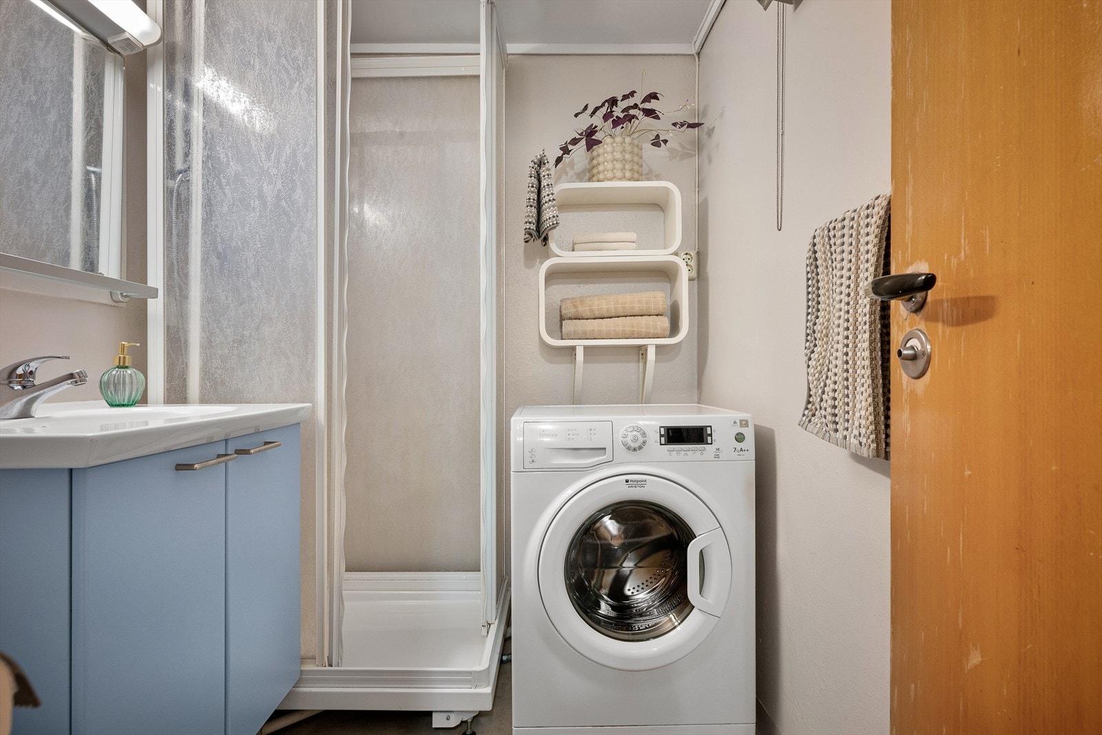 Badet med dusjkabinett, seksjon, wc og plass til vaskemaskin. Så slipper du å bruke felles vaskerom. Plass også til ekstra hyller. Galleribilde