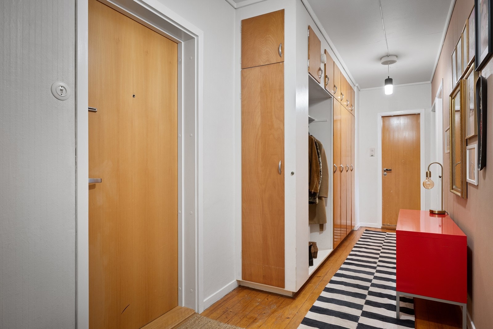 Gang med stedbyggede skap i lun stil. God plass til ekstra kommode og påkledningsbenk. Galleribilde