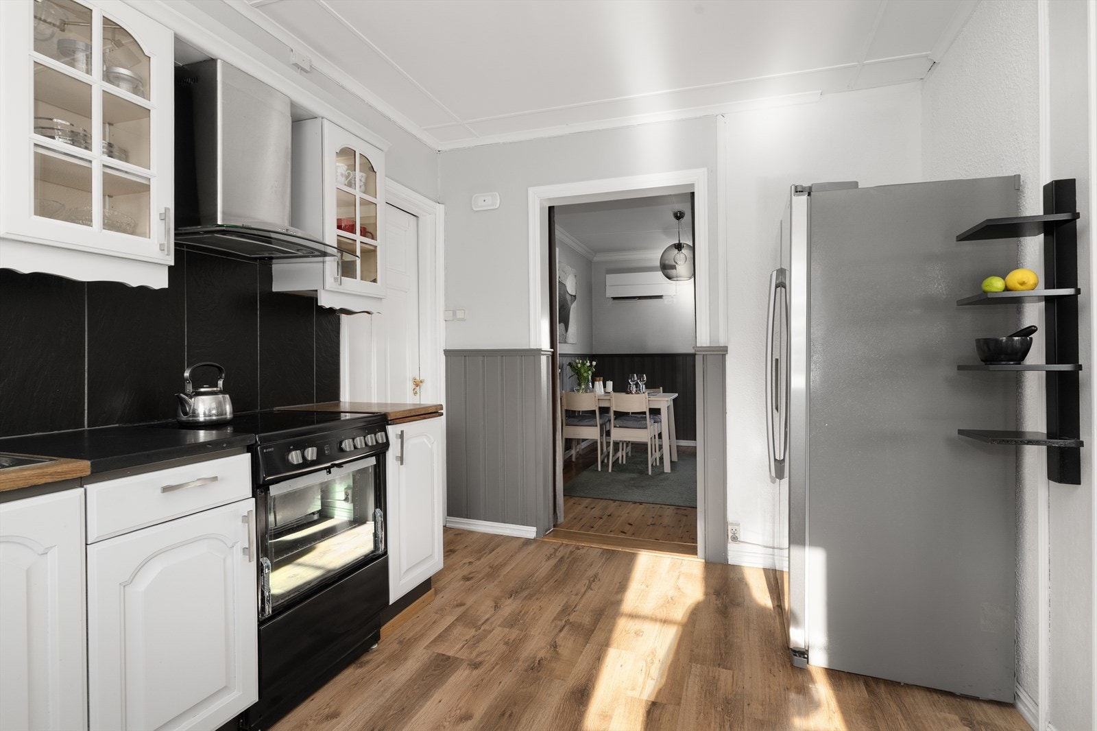 Kjøkkenet har avsatt plass til frittstående hvitevarer som oppvaskmaskin, komfyr og kjøl/fryseskap, og over kokesonen er det ventilator med avtrekk ut. Galleribilde