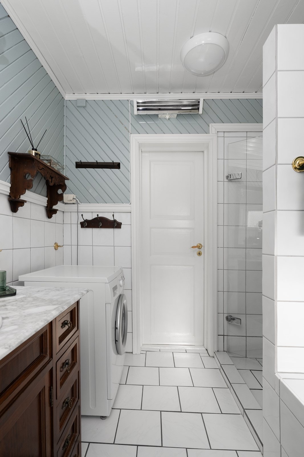 Badet har også innfliset badekar og egen fliset dusjnisje med glassdør, samt at det er opplegg for og plass til vaskemaskin. Galleribilde