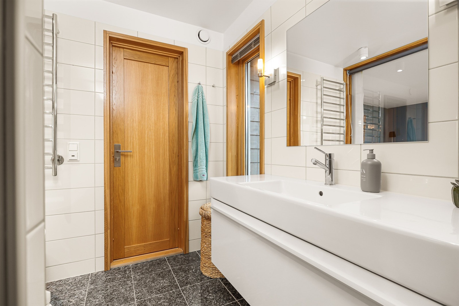 Badet er innredet med vegghengt baderomsinnredning fra Duravit med hvite, glatte skuffefronter og heldekkende servant med ettgreps blandebatteri. Galleribilde