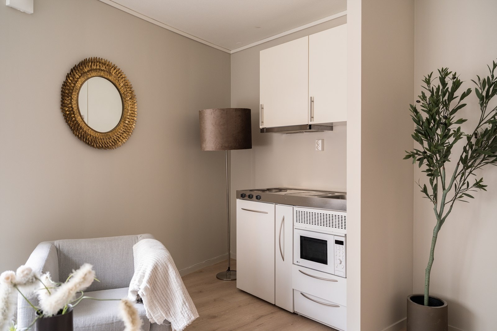 Pent kjøkken med glatte fronter og benkebeslag med vaskekum i rustfritt stål. Galleribilde