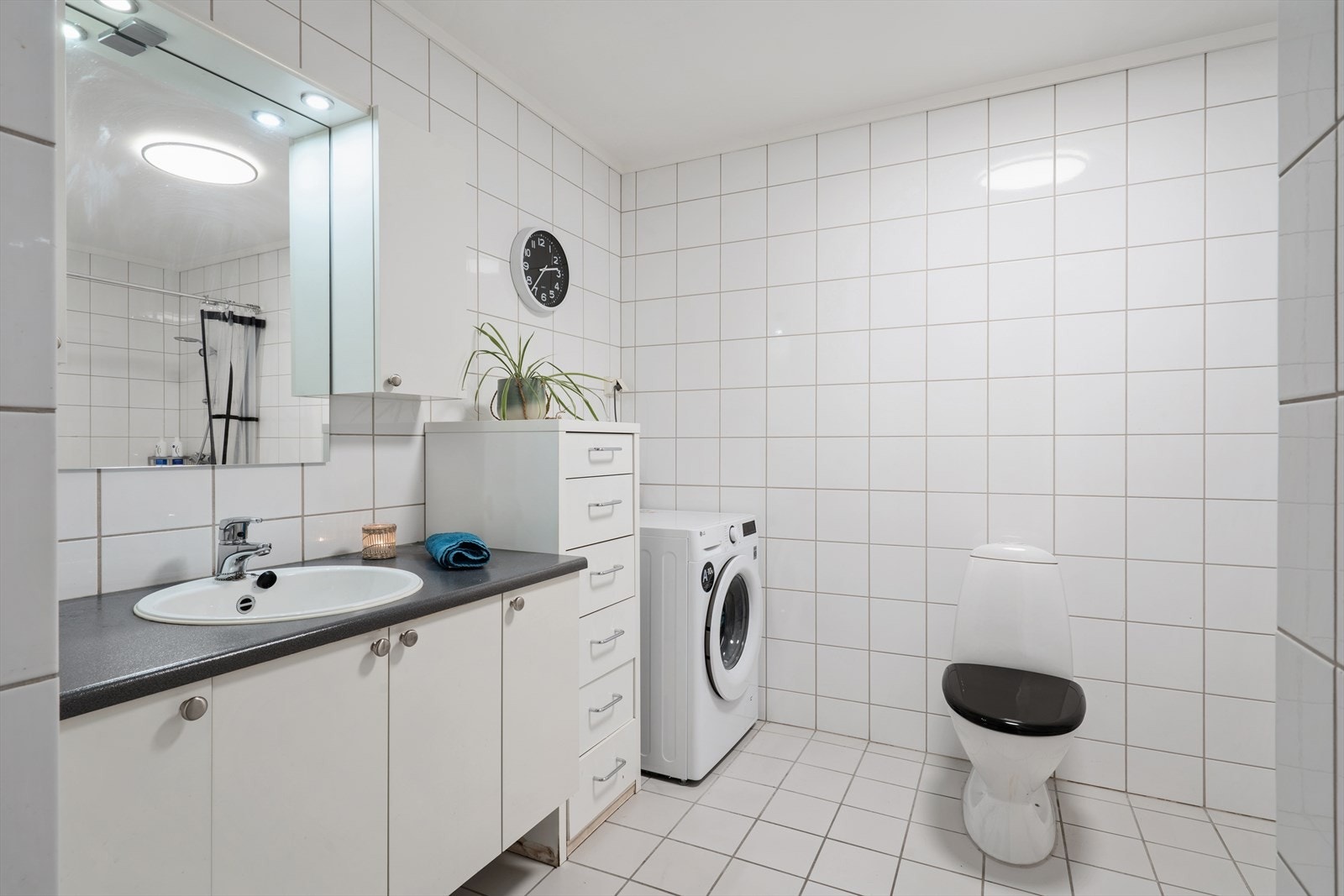 Helfliset baderom på 7,2 m² utstyrt med blant annet opplegg til vaskemaskin, toalett og servant med rikelig av oppbevaring i tilhørende skap. Galleribilde