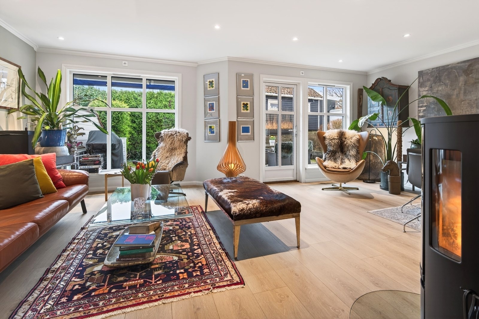 Romslig stue med store vinduer mot uteplassen Galleribilde