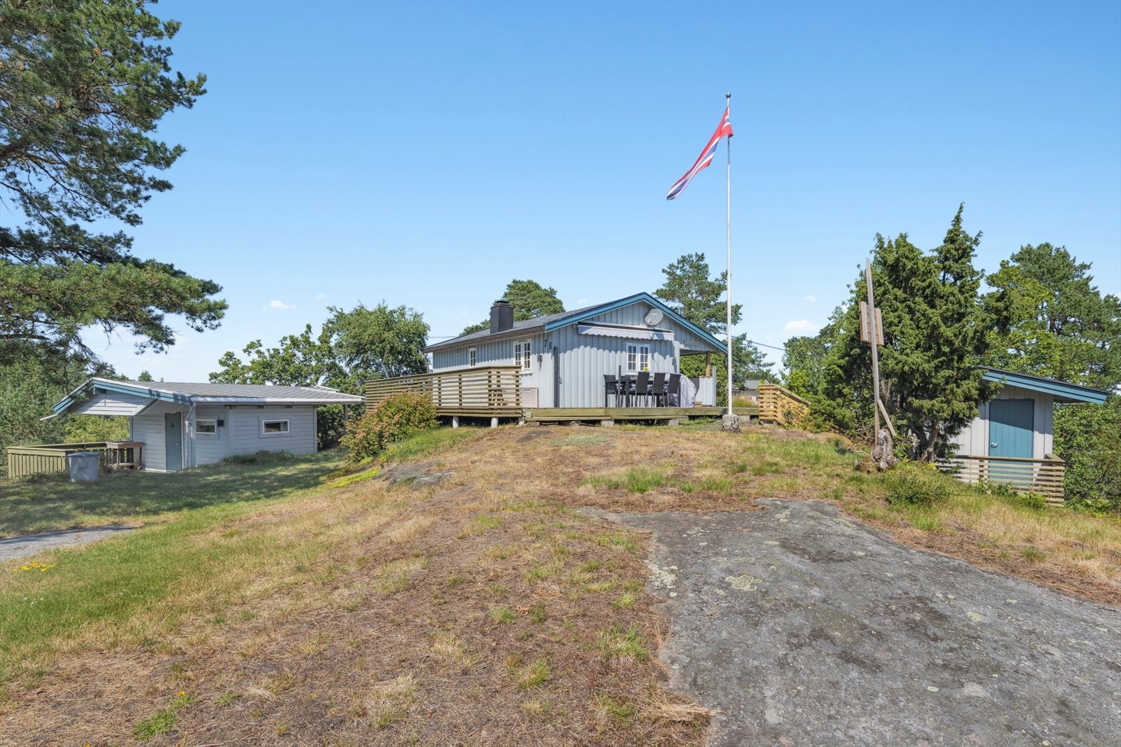 tomten ellers består av trær, prydbusker, plen og noen knauser Galleribilde