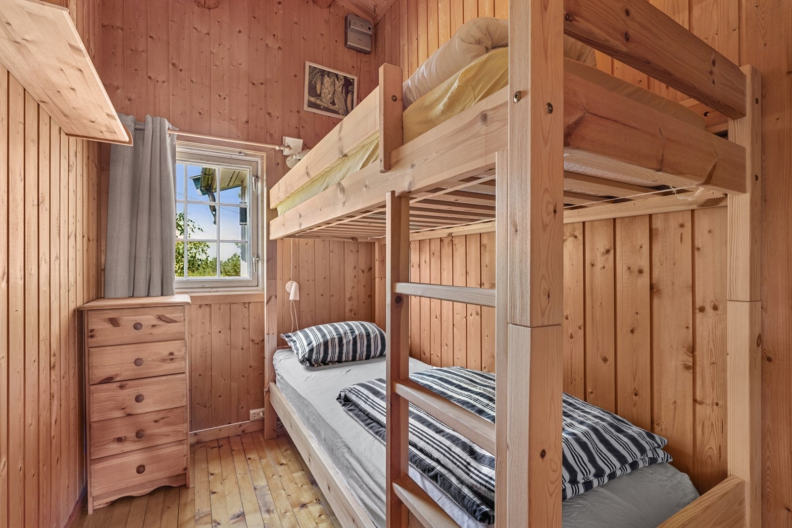 Ett av to soverom i hytta utstyrt med køyeseng Galleribilde