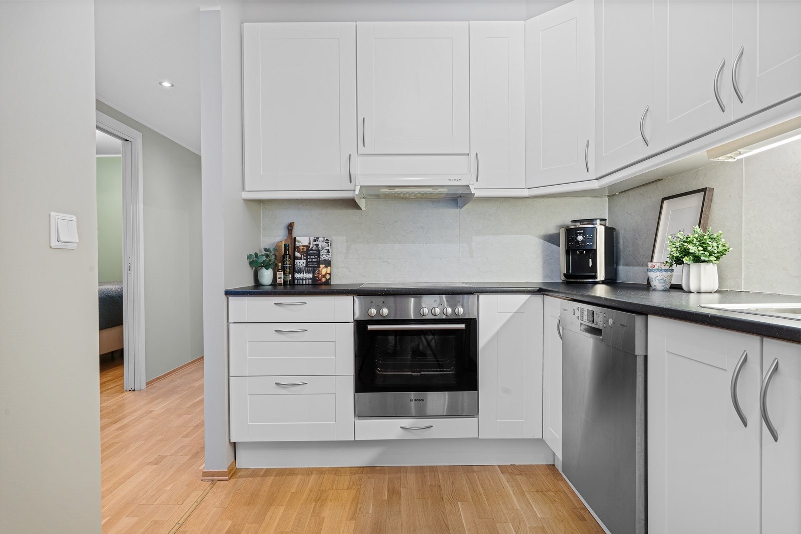 Kjøkkenet har profilerte fronter og en praktisk laminert benkeplate med integrert stålvask og platetopp Galleribilde