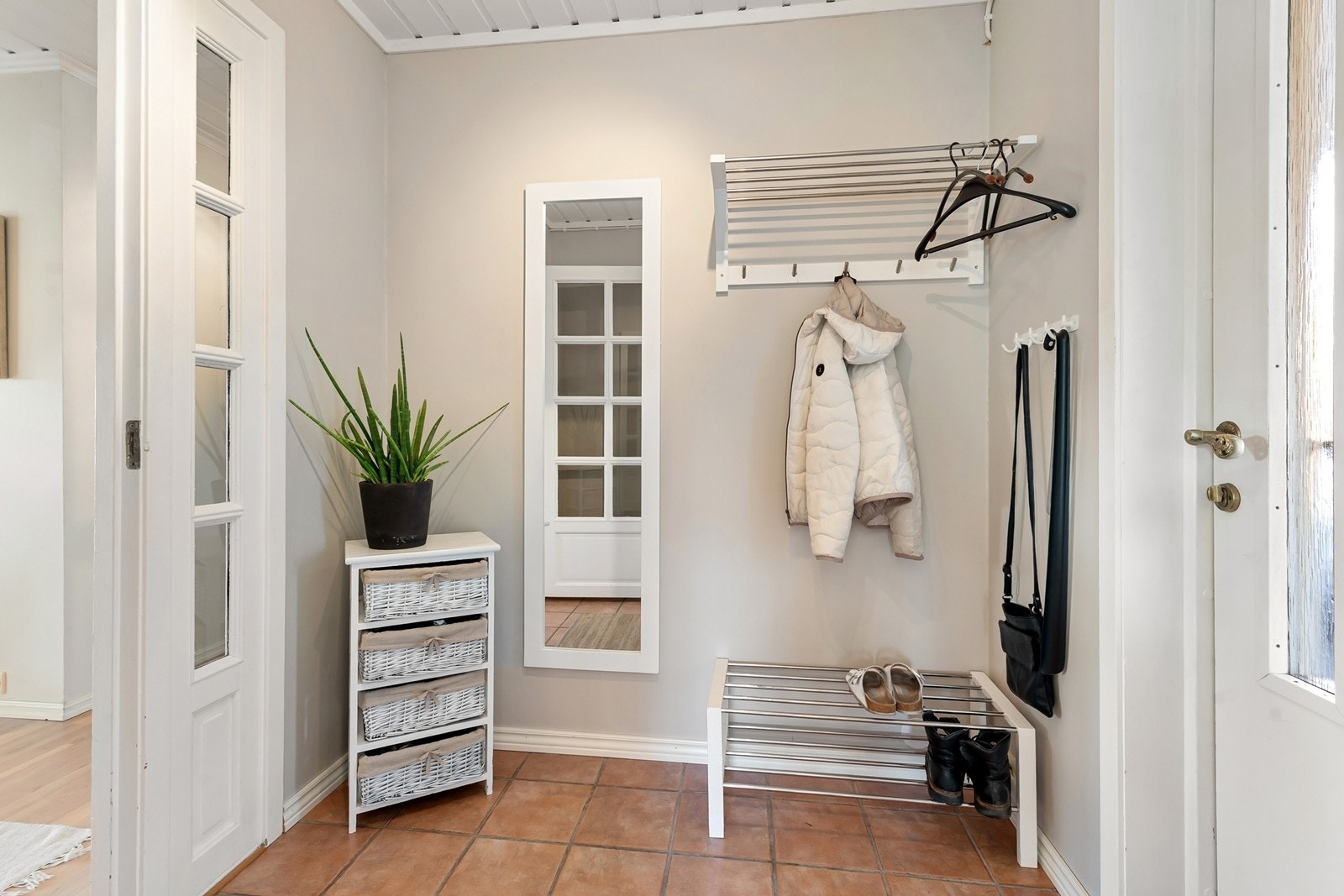 Velkommen inn i en romslig entré med flislagt gulv og plass til oppbevaring av yttertøy. Galleribilde