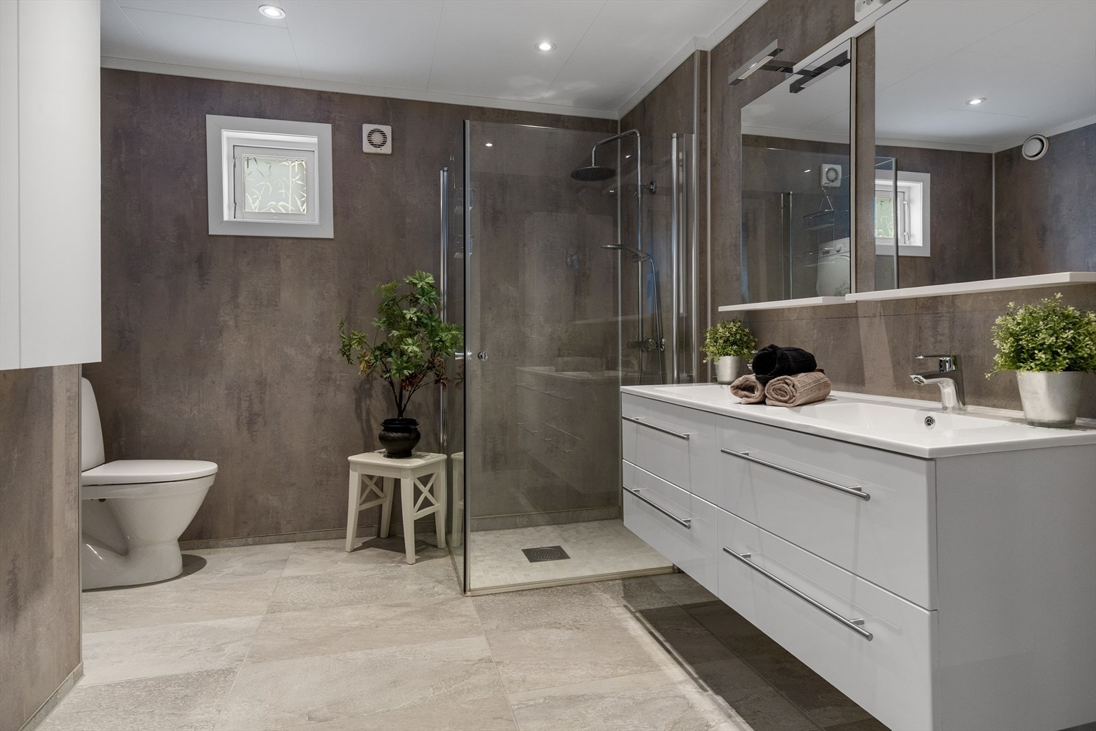 Badet er fra 2020/21, med flislagt gulv, varmekabler og moderne baderomsplater på veggene. Galleribilde