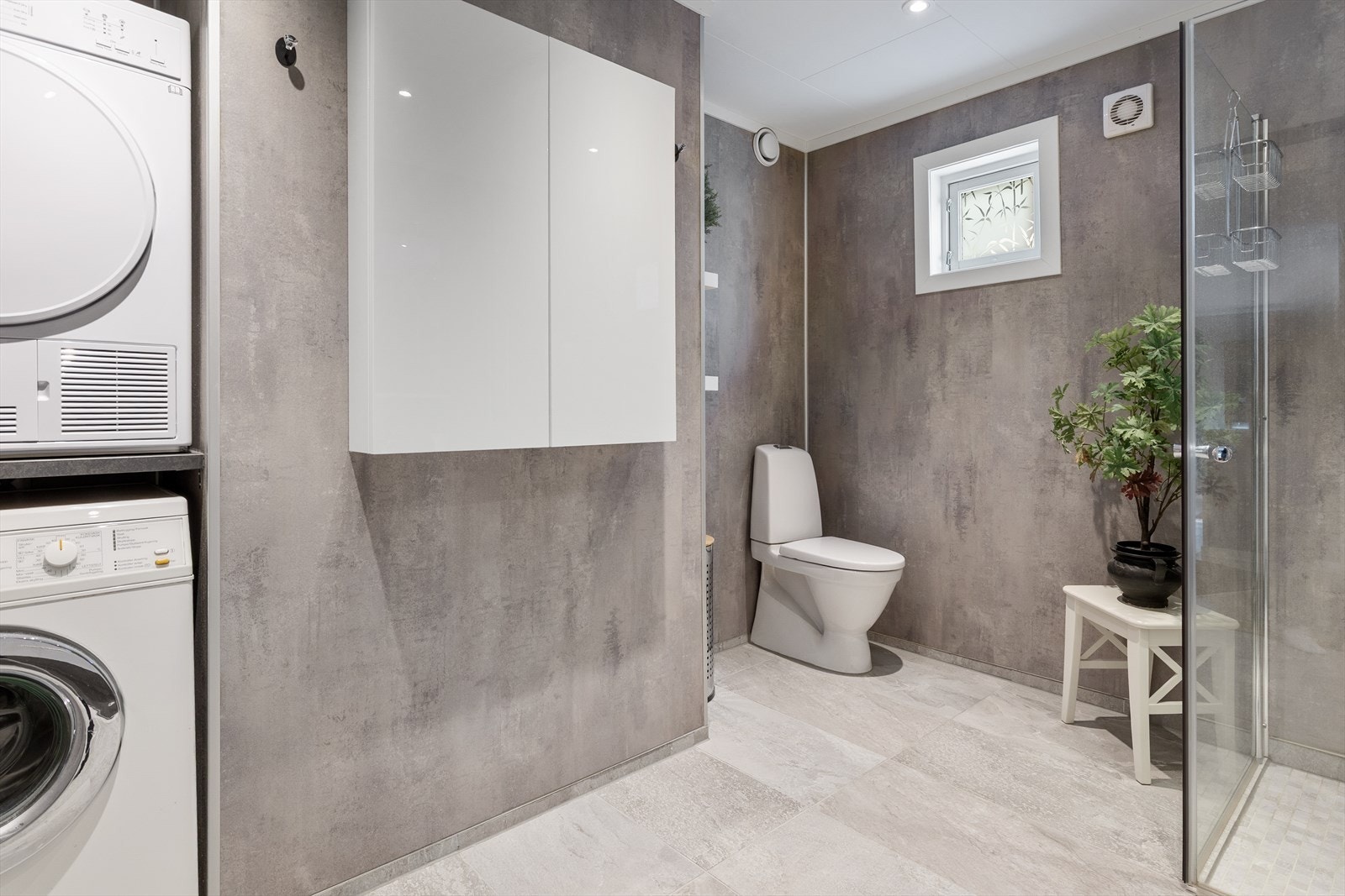 Badet er praktisk innredet med opplegg for vaskemaskin og tørketrommel. Galleribilde