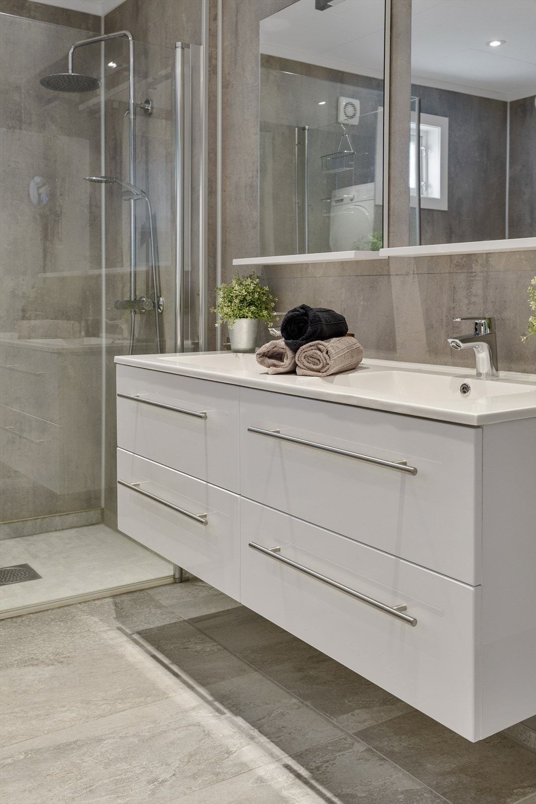 Baderomsinnredningen har to nedfelte servanter og godt med oppbevaringsplass i skuffer. Galleribilde