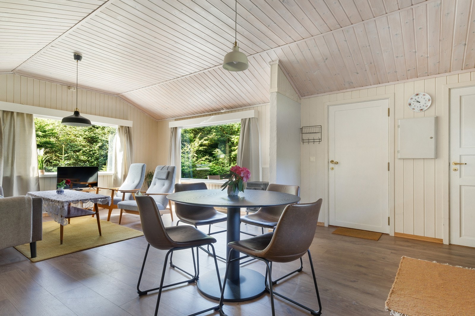 Store vindusflater gir utsyn mot grøntområde fra stuen. Galleribilde