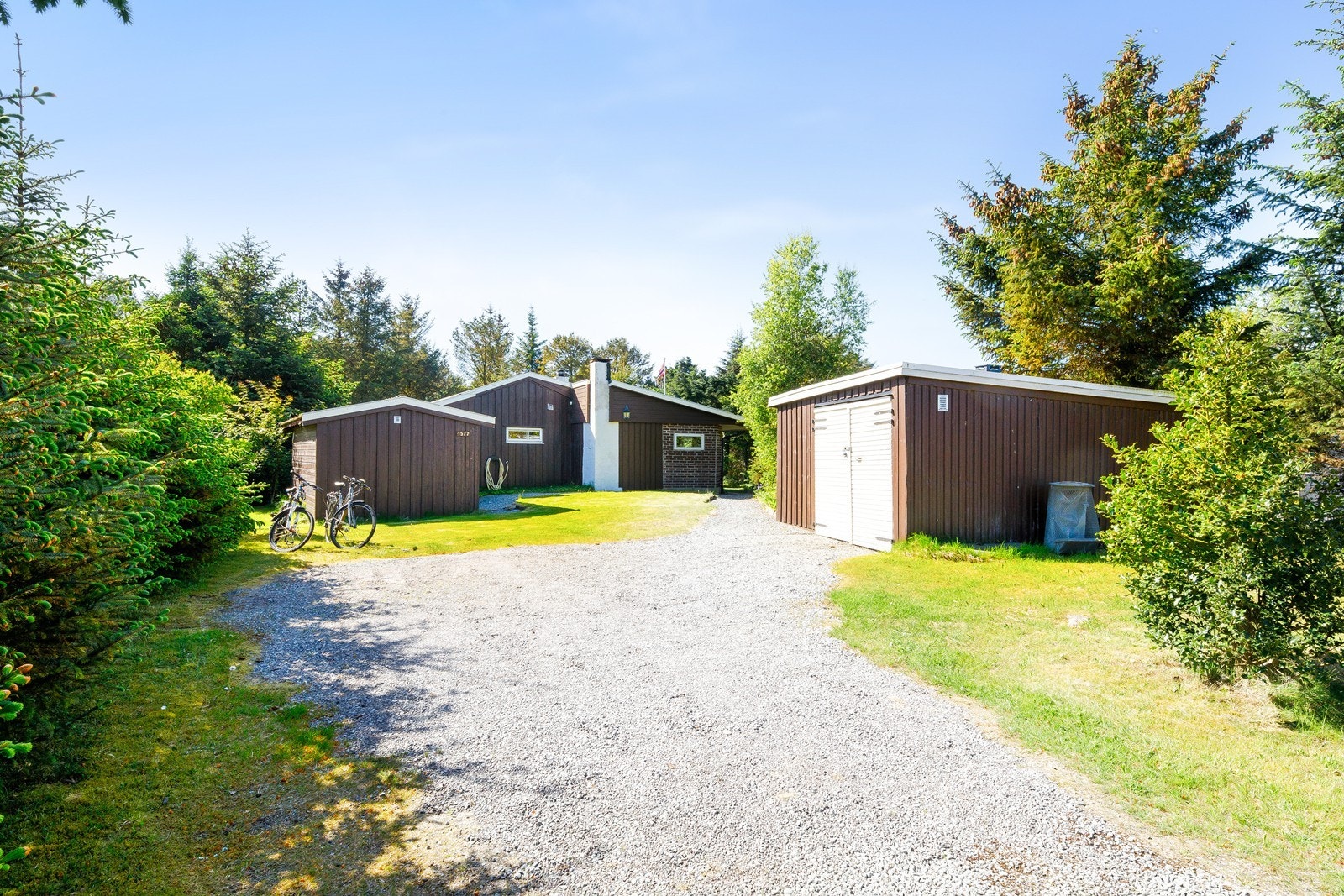 Gruslagt innkjørsel og gårdsrom gir god parkering, det er også garasjen som brukes flittig til oppbevaring av sykler mm. Galleribilde
