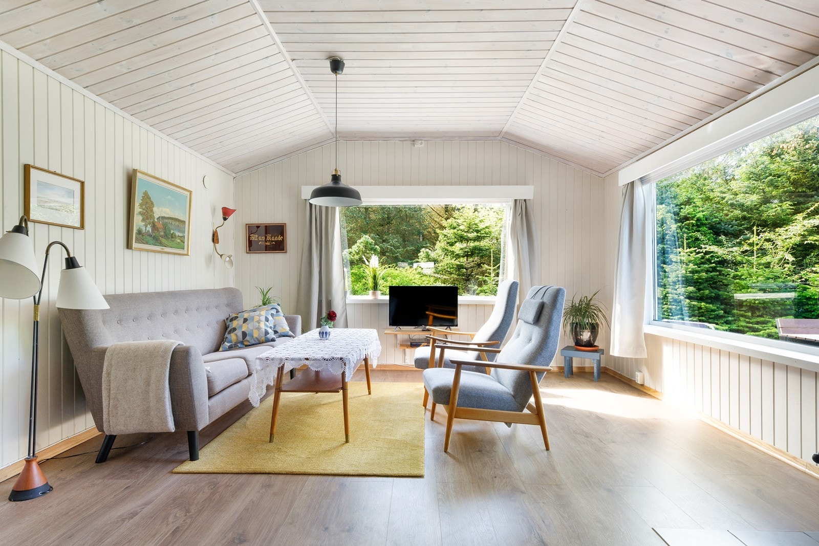 behandlet trepanel på vegger og tak gir en varm og koselig atmosfære i stuen. Galleribilde