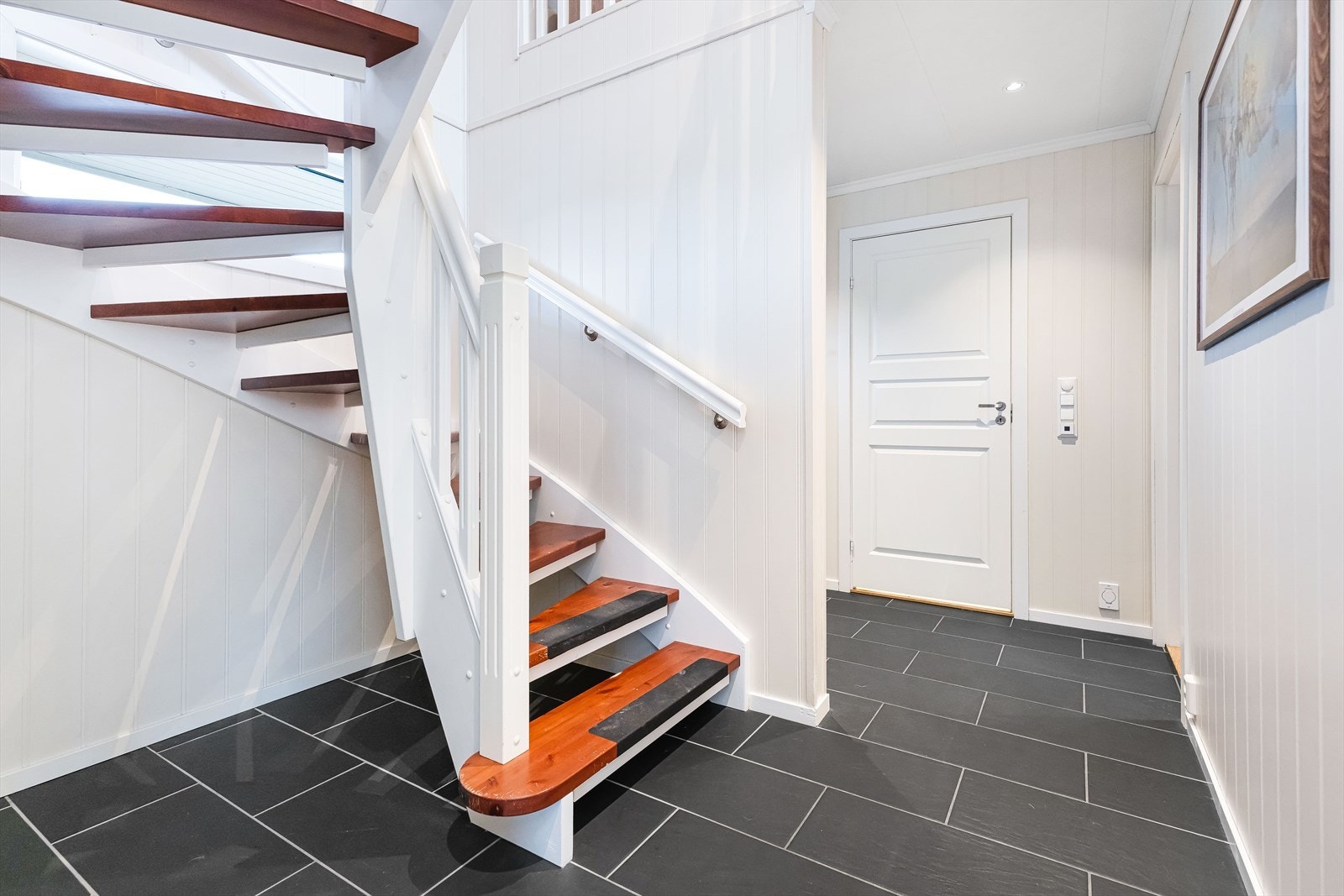 Videre inn i gangen er trappen opp til 2. etasje praktisk plassert mellom gang og stue/kjøkken. Galleribilde