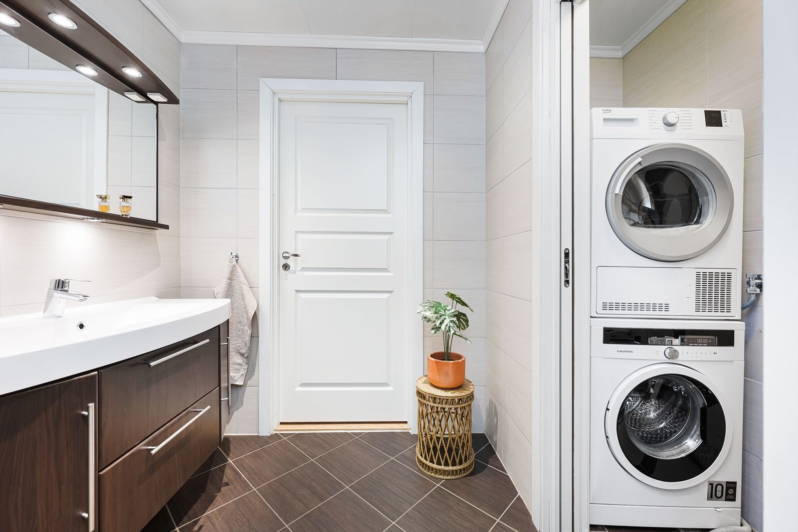 Fra badet kommer du til vaskerommet. Rommet er særdeles godt utnyttet og det er skyvedør mellom bad og vaskeromsdel. Galleribilde
