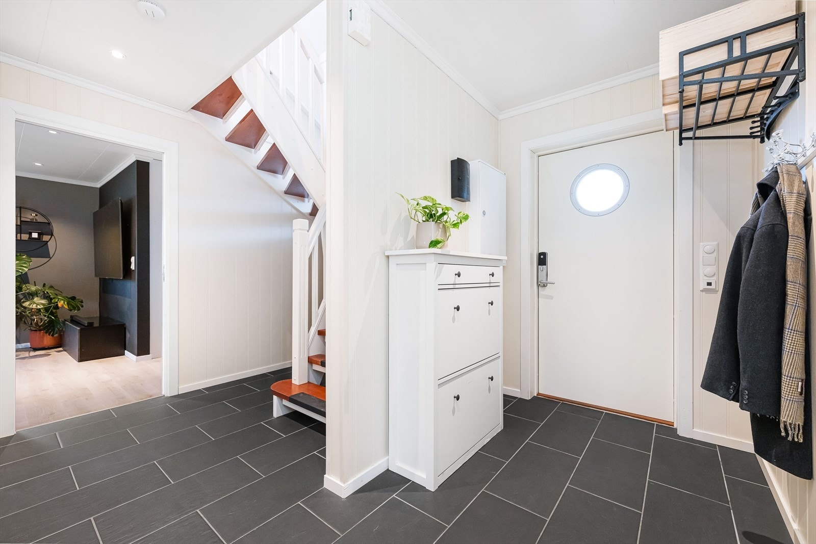 Romslig entre med flislagt gulv og naturlig adkomst videre inn i boligen. Lunt og behagelig førsteinntrykk med varmekabler i gulv. Galleribilde