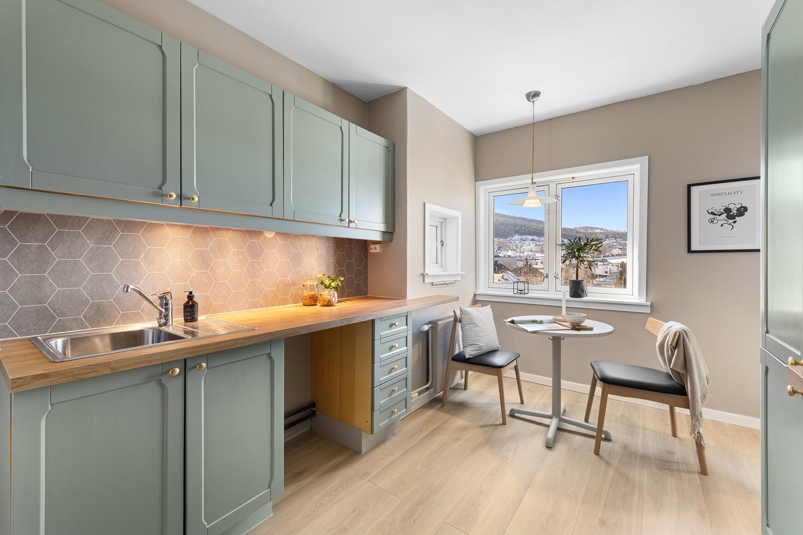 Leilighetens kjøkken har profilerte fronter og en solid benkeplate i laminat. Galleribilde